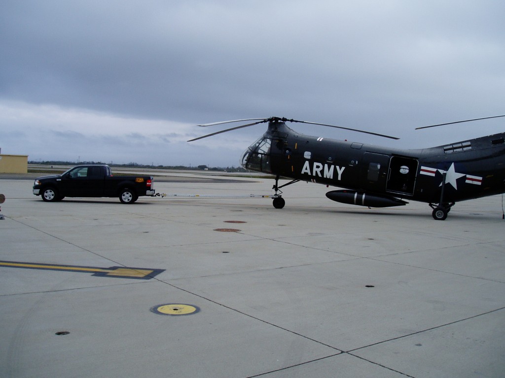 A Black Gold Industries pickup truck towing an Army helicopter